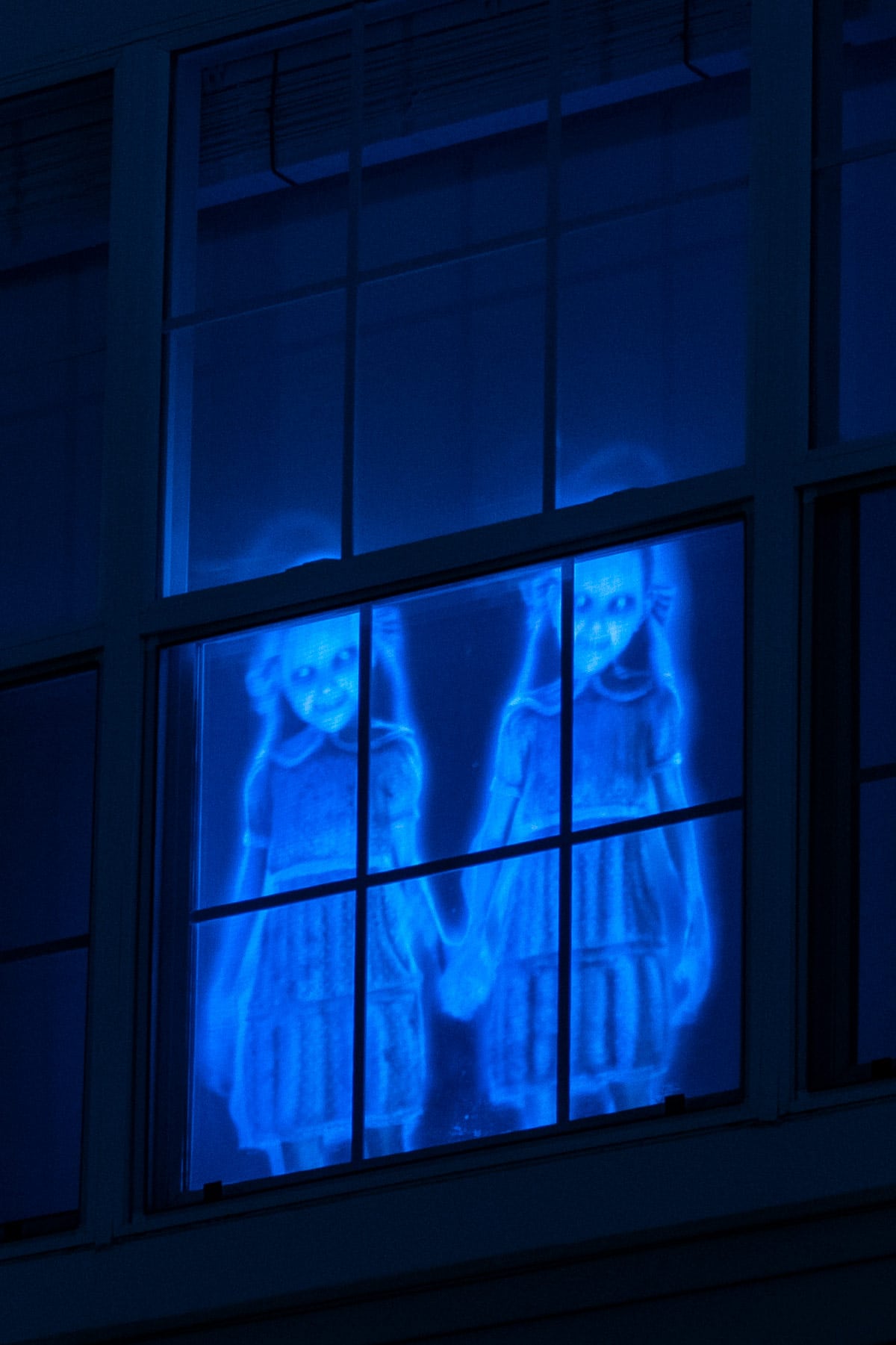 Spooky ghosts in the window for Halloween holographic window decorations.